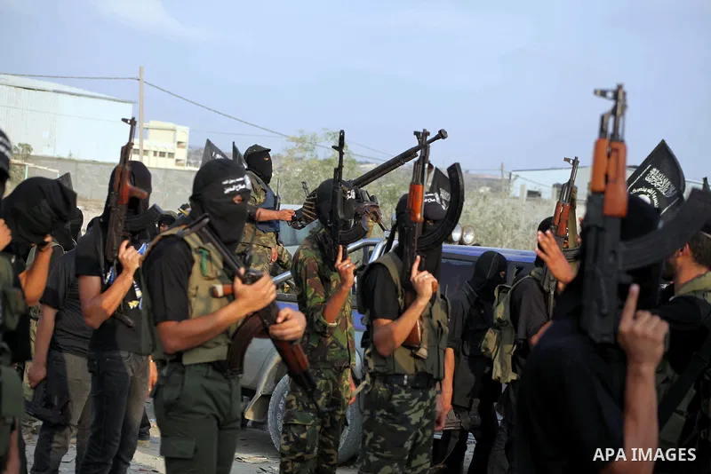 Palestinian militants from the Al Nasser Brigades, an armed wing of the Popular Resistance Committees (PRC) hold weapons during a rally marking the 12th anniversary of the brigades, in Gaza city, Friday, Sept. 28, 2012....