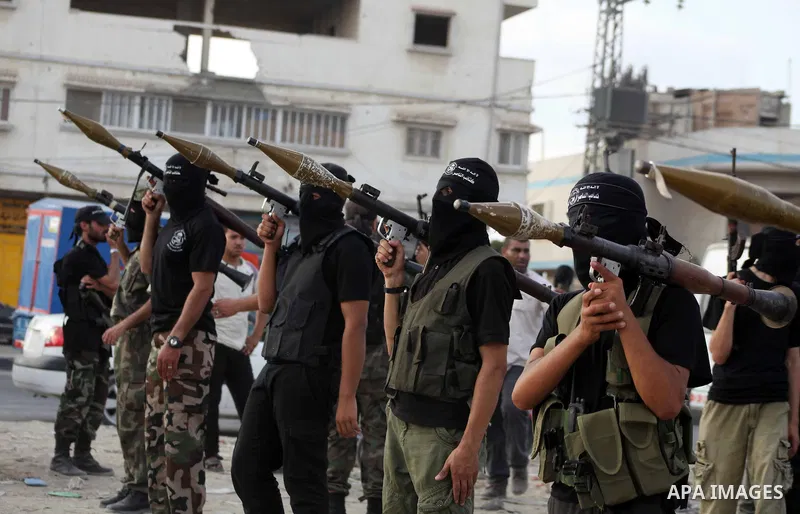Palestinian militants from the Al Nasser Brigades, an armed wing of the Popular Resistance Committees (PRC) hold weapons during a rally marking the 12th anniversary of the brigades, in Gaza city, Friday, Sept. 28, 2012....