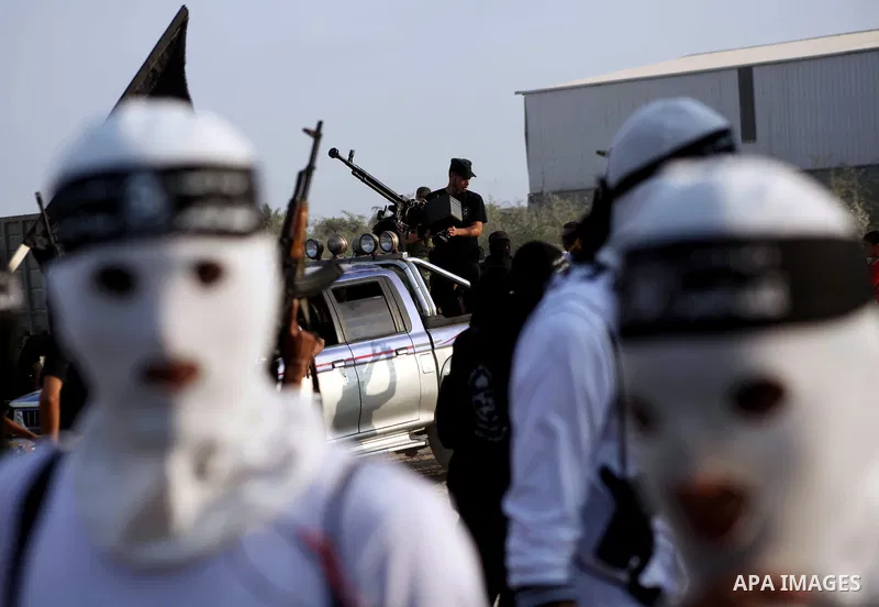 Palestinian militants from the Al Nasser Brigades, an armed wing of the Popular Resistance Committees (PRC) hold weapons during a rally marking the 12th anniversary of the brigades, in Gaza city, Friday, Sept. 28, 2012....