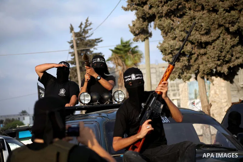 Palestinian militants from the Al Nasser Brigades, an armed wing of the Popular Resistance Committees (PRC) hold weapons during a rally marking the 12th anniversary of the brigades, in Gaza city, Friday, Sept. 28, 2012....