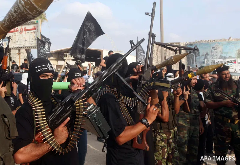 Palestinian militants from the Al Nasser Brigades, an armed wing of the Popular Resistance Committees (PRC) hold weapons during a rally marking the 12th anniversary of the brigades, in Gaza city, Friday, Sept. 28, 2012....