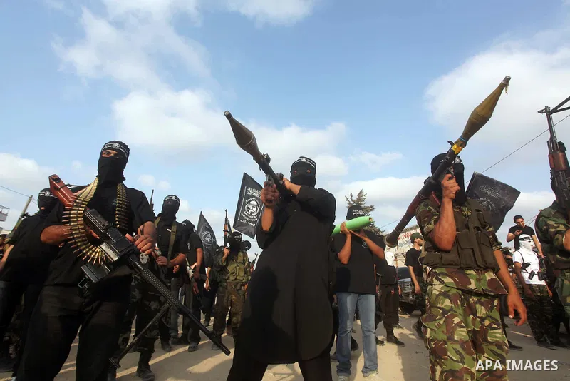 Palestinian militants from the Al Nasser Brigades, an armed wing of the Popular Resistance Committees (PRC) hold weapons during a rally marking the 12th anniversary of the brigades, in Gaza city, Friday, Sept. 28, 2012....