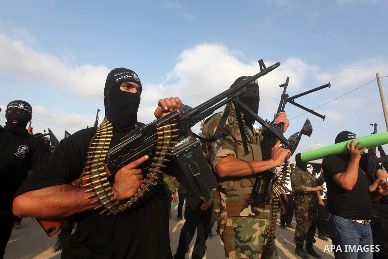 Palestinian militants from the Al Nasser Brigades, an armed wing of the Popular Resistance Committees (PRC) hold weapons during a rally marking the 12th anniversary of the brigades, in Gaza city, Friday, Sept. 28, 2012....