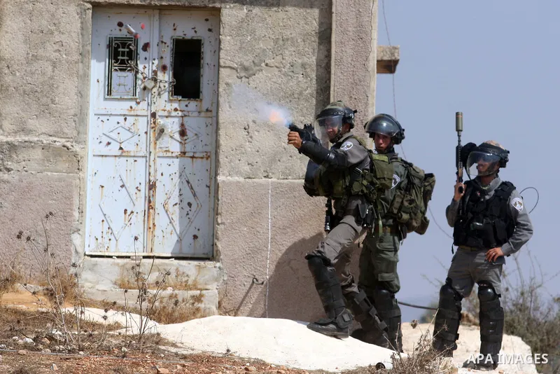 Israeli soldiers fire at Palestinian protesters during a weekly protest against the expansion of the nearby Jewish settlement of Halamish, in the West Bank village of Nabi Saleh near Ramallah, Friday, Sept 28, 2012. Phot...