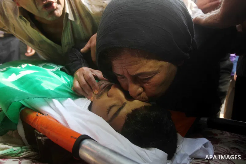 Relatives of Palestinian fisherman Fahmi Abu Rayash mourn over his body during his funeral in Beit Lahia in the northern Gaza Strip on September 29, 2012. Abu Rayash died of his wounds after the Israeli navy opened fire...