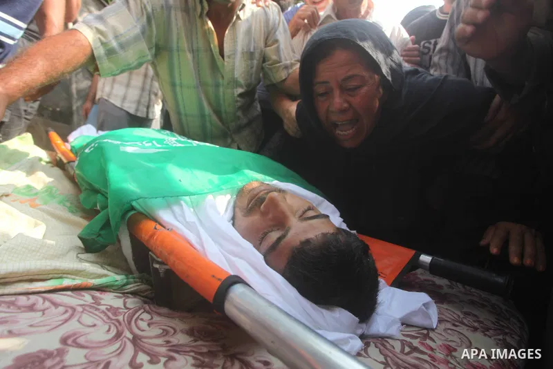Relatives of Palestinian fisherman Fahmi Abu Rayash mourn over his body during his funeral in Beit Lahia in the northern Gaza Strip on September 29, 2012. Abu Rayash died of his wounds after the Israeli navy opened fire...