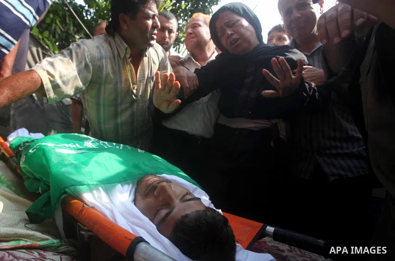 Relatives of Palestinian fisherman Fahmi Abu Rayash mourn over his body during his funeral in Beit Lahia in the northern Gaza Strip on September 29, 2012. Abu Rayash died of his wounds after the Israeli navy opened fire...