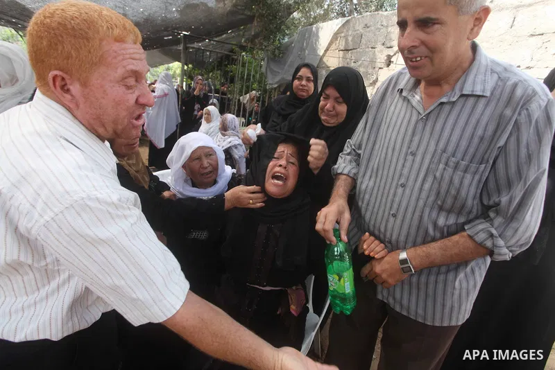 Relatives of Palestinian fisherman Fahmi Abu Rayash mourn over his body during his funeral in Beit Lahia in the northern Gaza Strip on September 29, 2012. Abu Rayash died of his wounds after the Israeli navy opened fire...