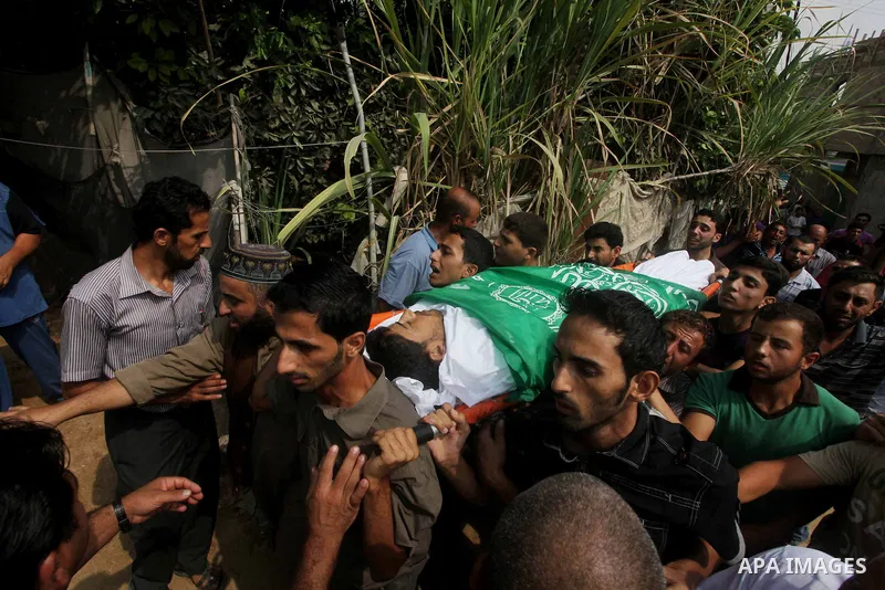 Relatives of Palestinian fisherman Fahmi Abu Rayash mourn over his body during his funeral in Beit Lahia in the northern Gaza Strip on September 29, 2012. Abu Rayash died of his wounds after the Israeli navy opened fire...