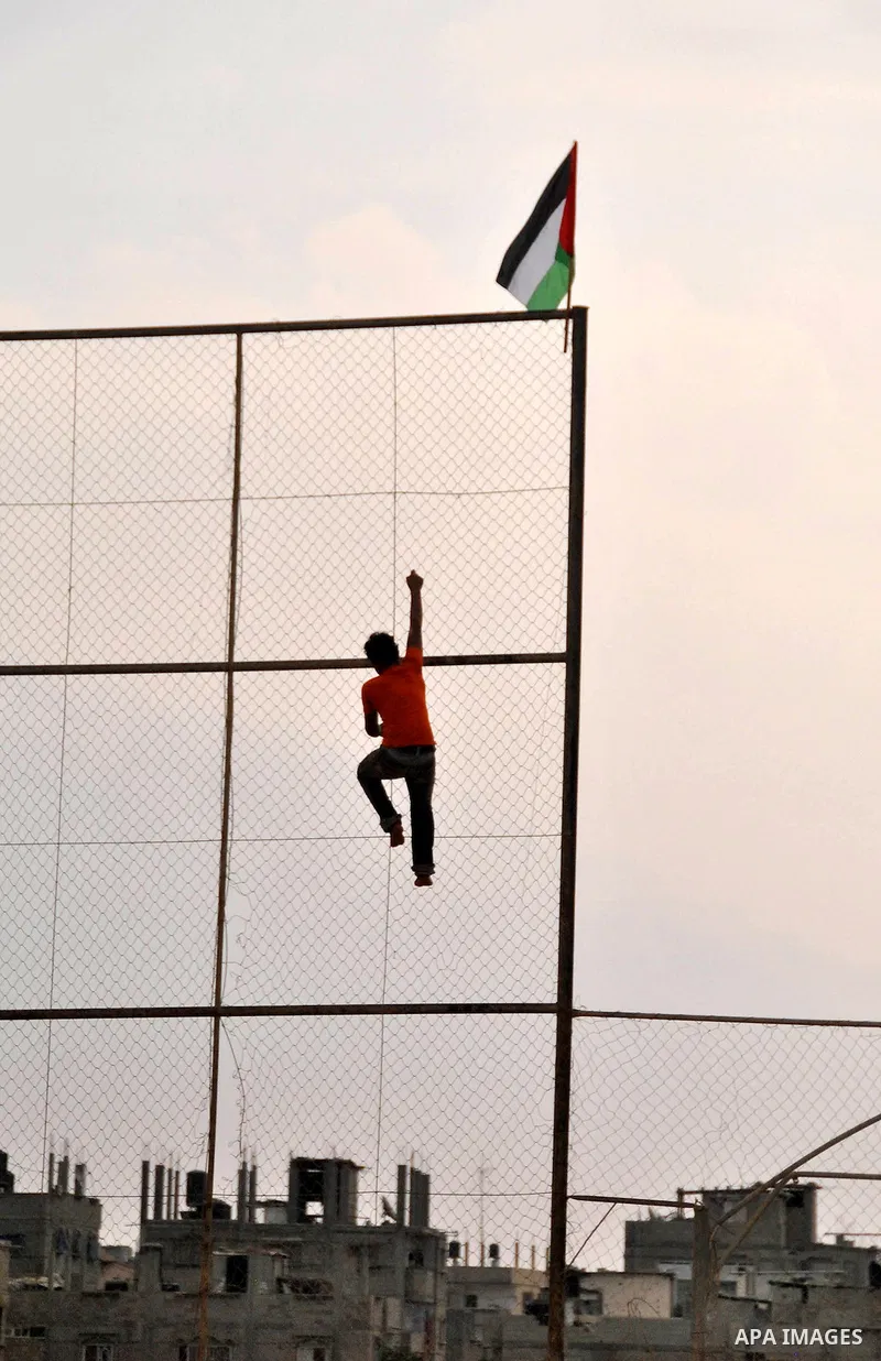 A Palestinian youth waves his national flag during a protest in Rafah, southern Gaza Strip, Sunday, Sept. 30, 2012. Hamas officials say that over the past two months, Egypt has closed about 80 percent of the roughly 450...