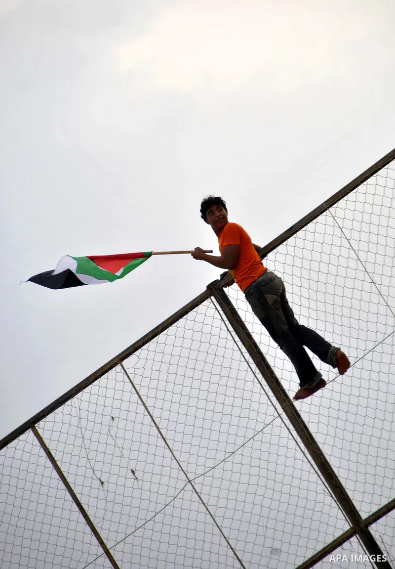 A Palestinian youth waves his national flag during a protest in Rafah, southern Gaza Strip, Sunday, Sept. 30, 2012. Hamas officials say that over the past two months, Egypt has closed about 80 percent of the roughly 450...