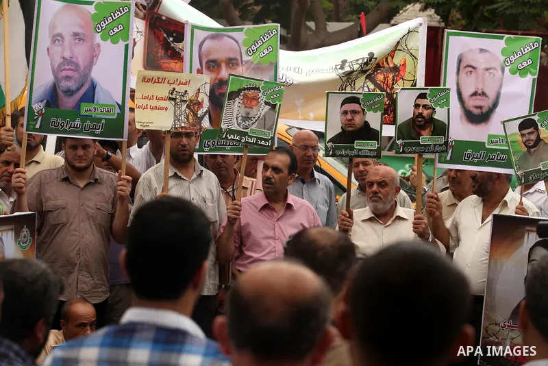 Palestinians hold pictures of their relatives prisoners held in Israeli jails during a rally calling for their release in front of the red cross office in Gaza city October 1, 2012. Photo by Majdi Fathi