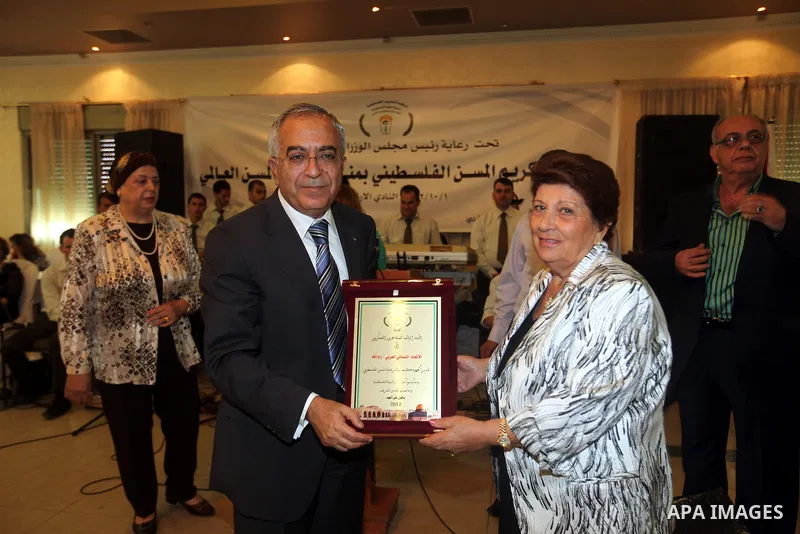 Palestinian Prime Minister Salam Fayyad honors an elderly woman during the the ceremony of the International Day of Older Persons in the West Bank city of Ramallah on October 1, 2012. The Day of Older Persons is celebrat...
