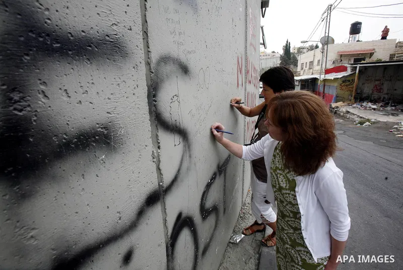 Members of European parliamentary delegation write on the separation barrier during a visit to Abu Dis in the south Jerusalem on october 1, 2012. Photo by Mahfouz Abu Turk