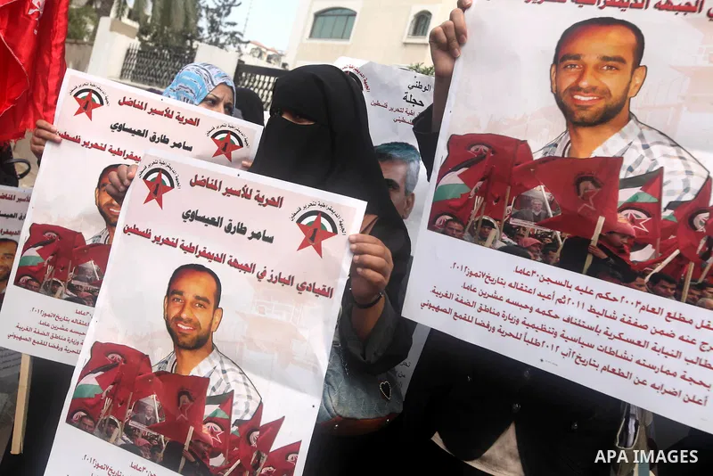 Supporters of Democratic Front for the Liberation of Palestine (DFLP) hold flags and portraits of Palestinian prisoners held in Israeli jails during a rally calling for their release, in Gaza city on october 2, 2012. Pho...