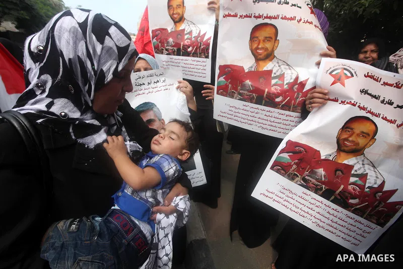 Supporters of Democratic Front for the Liberation of Palestine (DFLP) hold flags and portraits of Palestinian prisoners held in Israeli jails during a rally calling for their release, in Gaza city on october 2, 2012. Pho...