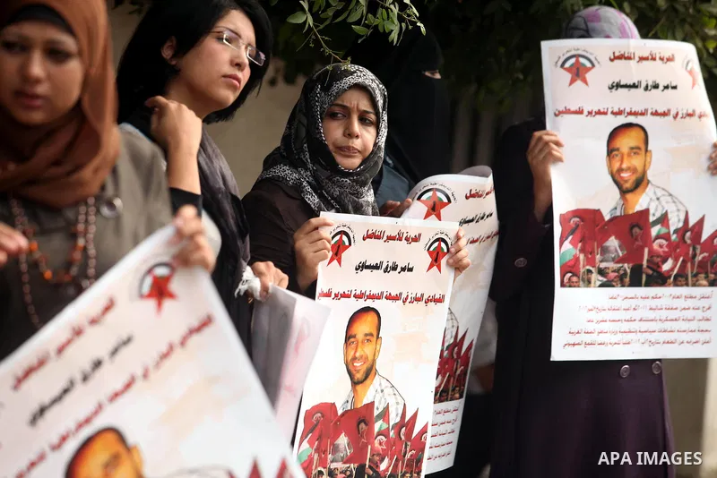 Supporters of Democratic Front for the Liberation of Palestine (DFLP) hold flags and portraits of Palestinian prisoners held in Israeli jails during a rally calling for their release, in Gaza city on october 2, 2012. Pho...