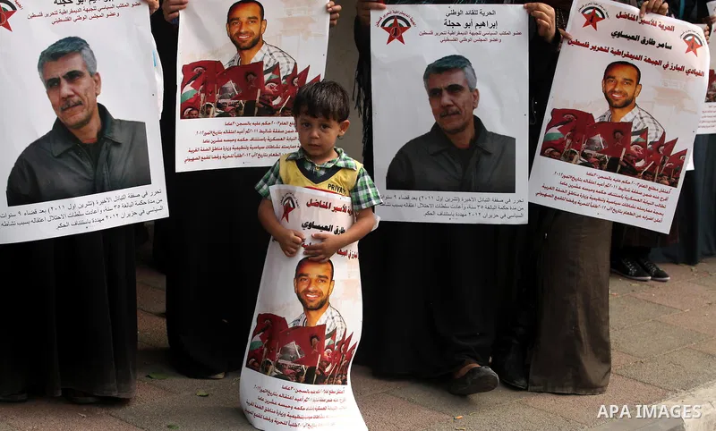 Supporters of Democratic Front for the Liberation of Palestine (DFLP) hold flags and portraits of Palestinian prisoners held in Israeli jails during a rally calling for their release, in Gaza city on october 2, 2012. Pho...