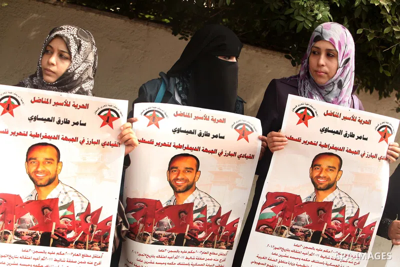 Supporters of Democratic Front for the Liberation of Palestine (DFLP) hold flags and portraits of Palestinian prisoners held in Israeli jails during a rally calling for their release, in Gaza city on october 2, 2012. Pho...