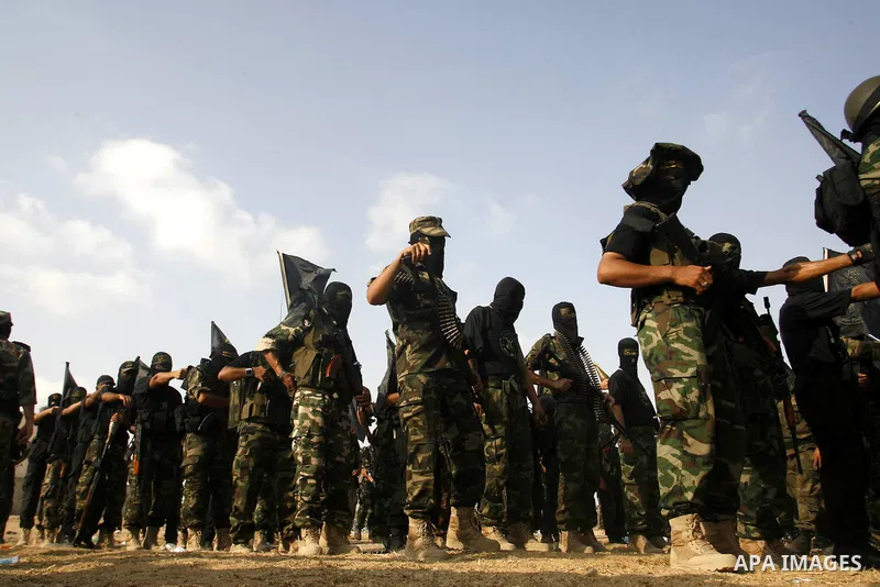 Palestinian militants from the Islamic Jihad, an armed wing of the Al-Quds Brigades hold weapons during a rally marking the 25th anniversary of the Jihad movement's establishment in Rafah in the southern Gaza Strip on Oc...