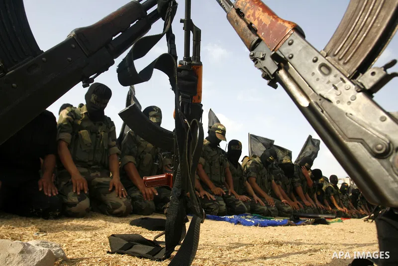 Palestinian militants from the Islamic Jihad, an armed wing of the Al-Quds Brigades Pray during a rally marking the 25th anniversary of the Jihad movement's establishment in Rafah in the southern Gaza Strip on October 2,...