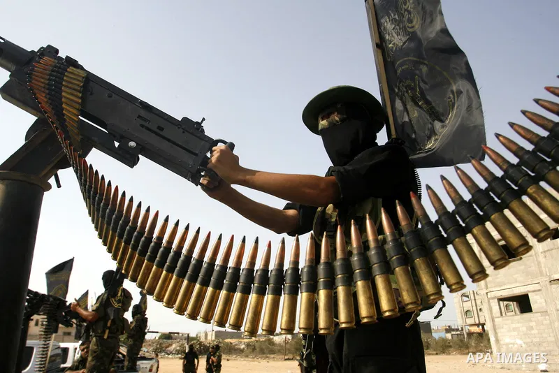 Palestinian militants from the Islamic Jihad, an armed wing of the Al-Quds Brigades hold weapons during a rally marking the 25th anniversary of the Jihad movement's establishment in Rafah in the southern Gaza Strip on Oc...