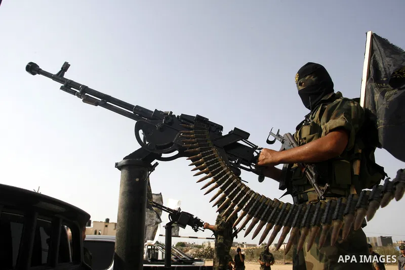 Palestinian militants from the Islamic Jihad, an armed wing of the Al-Quds Brigades hold weapons during a rally marking the 25th anniversary of the Jihad movement's establishment in Rafah in the southern Gaza Strip on Oc...