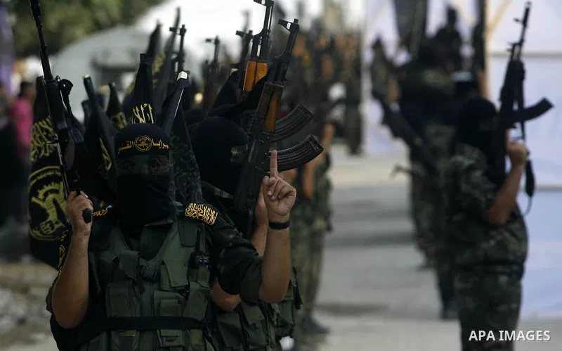 Palestinian militants from the Islamic Jihad, an armed wing of the Al-Quds Brigades hold weapons during a rally marking the 25th anniversary of the Jihad movement's establishment in Rafah in the southern Gaza Strip on Oc...