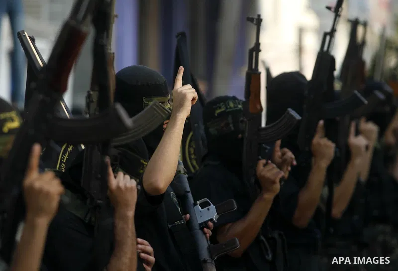 Palestinian militants from the Islamic Jihad, an armed wing of the Al-Quds Brigades hold weapons during a rally marking the 25th anniversary of the Jihad movement's establishment in Rafah in the southern Gaza Strip on Oc...