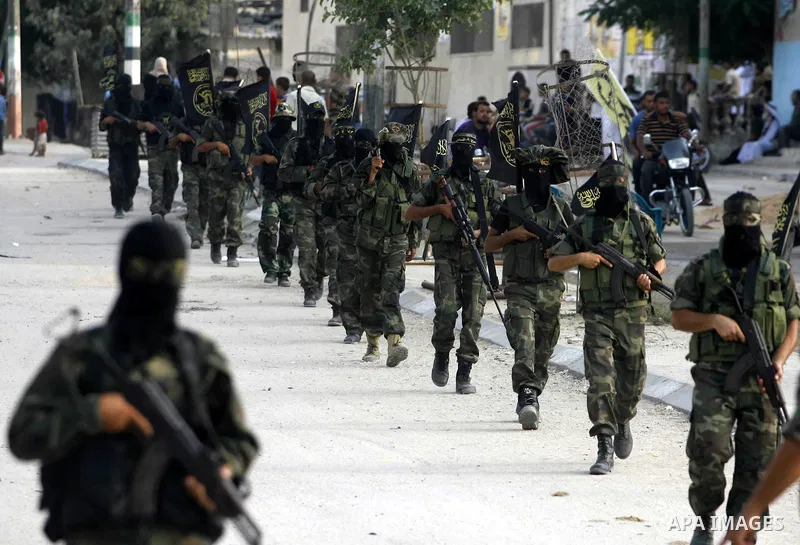 Palestinian militants from the Islamic Jihad, an armed wing of the Al-Quds Brigades hold weapons during a rally marking the 25th anniversary of the Jihad movement's establishment in Rafah in the southern Gaza Strip on Oc...