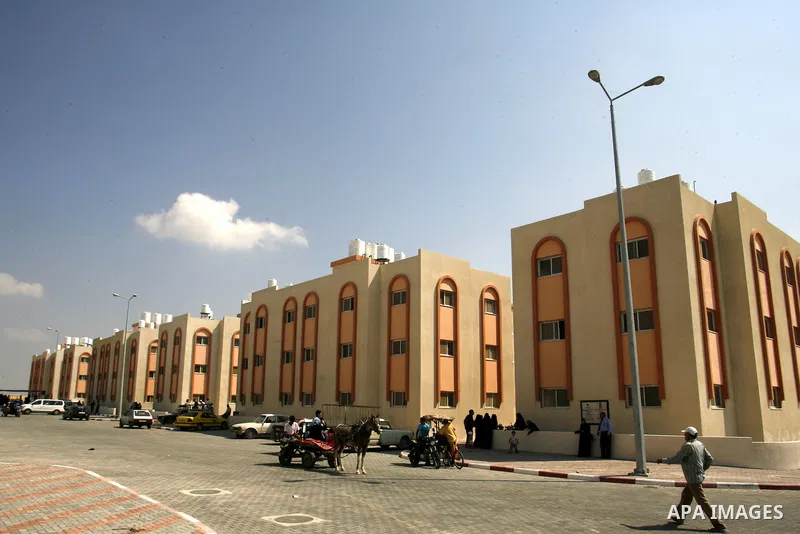 Palestinians walk in front of their new houses in a project funded by the United Nations Relief and Works Agency for Palestine Refugees (UNRWA) in Rafah, in the southern of Gaza Strip on Oct. 03, 2012. Palestinians whose...
