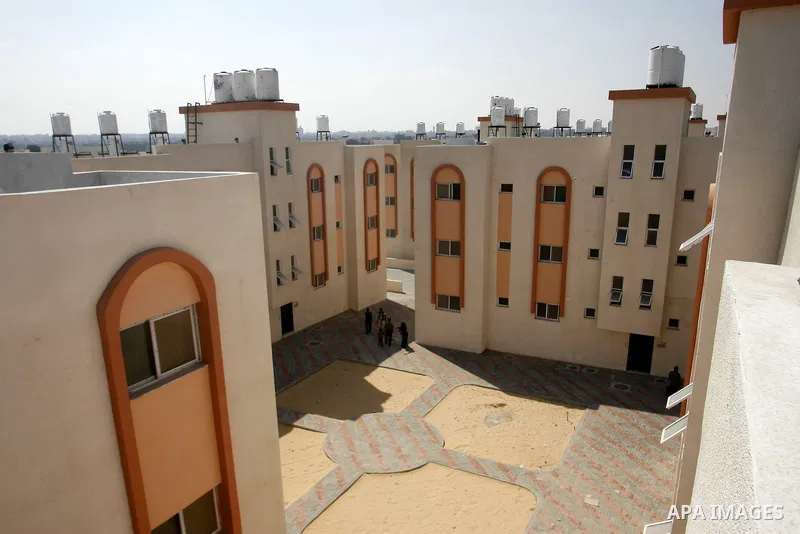 Palestinians walk in front of their new houses in a project funded by the United Nations Relief and Works Agency for Palestine Refugees (UNRWA) in Rafah, in the southern of Gaza Strip on Oct. 03, 2012. Palestinians whose...