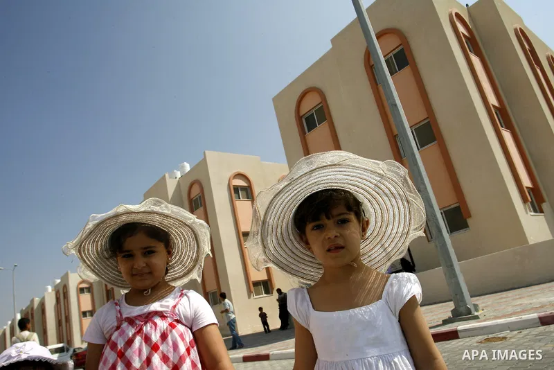 Palestinians walk in front of their new houses in a project funded by the United Nations Relief and Works Agency for Palestine Refugees (UNRWA) in Rafah, in the southern of Gaza Strip on Oct. 03, 2012. Palestinians whose...