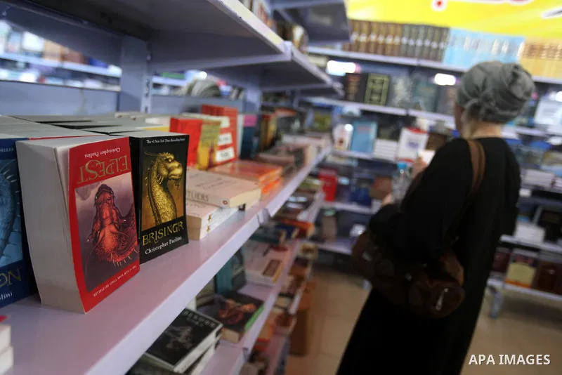A Palestinian visitor reads a book at a booth during the launch of the International Book Fair Exhibition, in Gaza city , Oct. 03, 2012. The Gaza International Book Fair has participated with more than 70 publishers from...