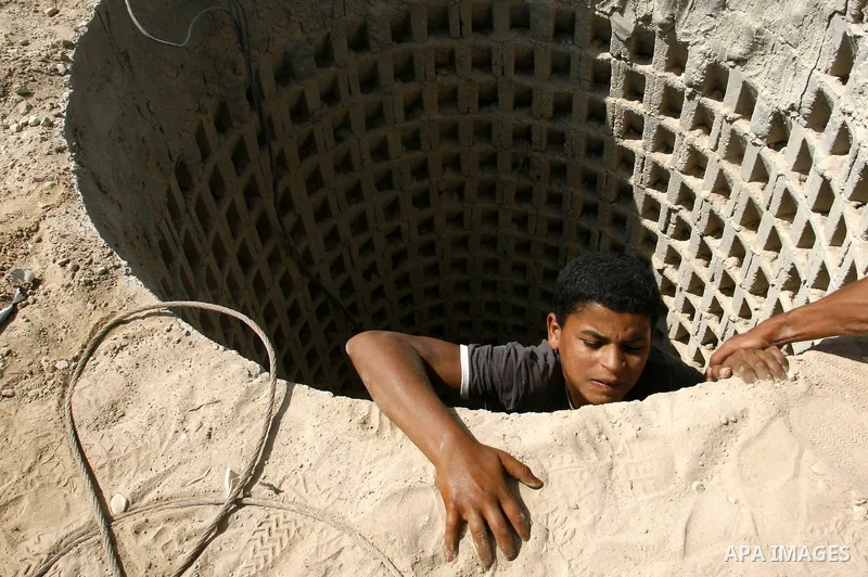 A Palestinian man helps a smuggler to ascend a tunnel along the Gaza-Egypt border in Rafah, in the southern Gaza Strip on September 30, 2012. Since last month, Egyptian military have destroyed about 30 tunnels and blocke...