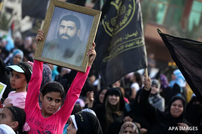 A Palestinian girl holds a picture of prisoner in Israeli jails during a ceremony marking the 25th anniversary of the establishment of Islamic Jihad movement and the 17th anniversary of the death of the group's leader Fa...