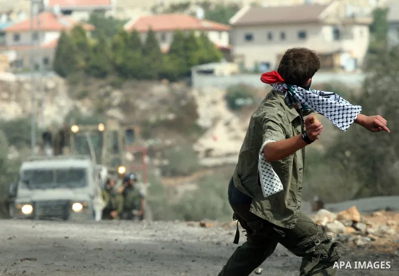 A Palestinian protester throws stones at Israeli soliders during clashes following a demonstration against the expropriation of Palestinian land by Israel in the village of Kafr Qadum in the occupied West Bank on October...