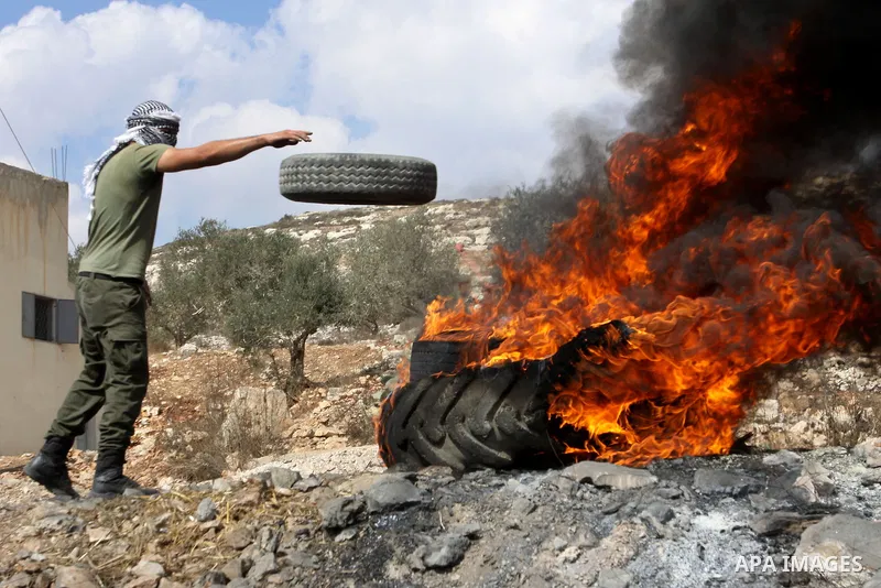 A Palestinian protester burns a tire during clashes with Israeli soldiers following a demonstration against the expropriation of Palestinian land by Israel in the village of Kafr Qadum in the occupied West Bank on Octobe...