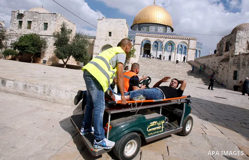 Palestinian medics carry a wounded worshipper during clashes at the Al Aqsa Mosque compound, known by the Jews as the Temple Mount, in Jerusalem's Old City, Friday, Oct. 5, 2012. Earlier this week, hardline Jewish activi...
