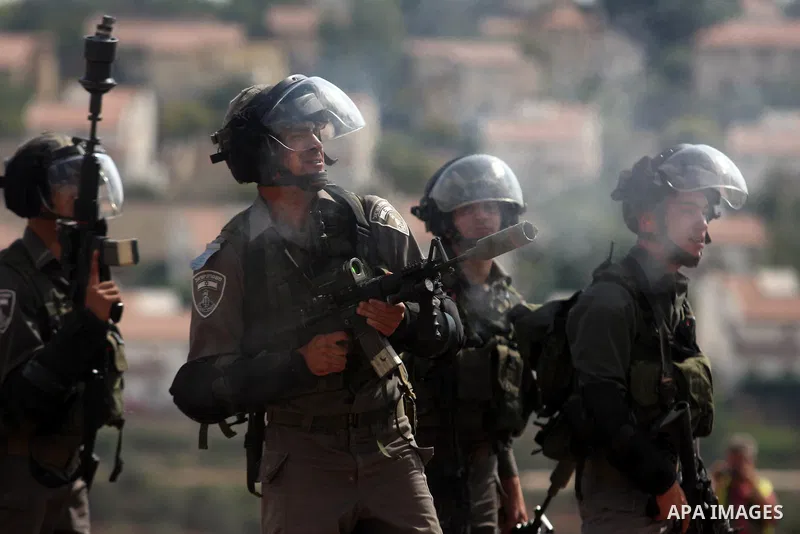 Israeli soldiers fire tear gas toward Palestinian demonstrators during a weekly protest against the expansion of the nearby Jewish settlement of Halamish, in the West Bank village of Nabi Saleh near Ramallah, Friday, Oct...