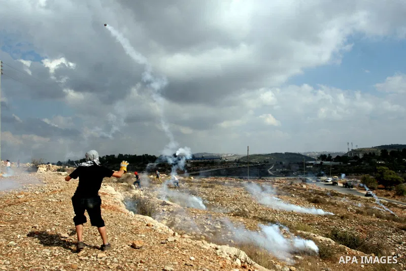Palestinian protesters run from tear gas during a weekly protest against the expansion of the nearby Jewish settlement of Halamish, in the West Bank village of Nabi Saleh near Ramallah, Friday, Oct 5, 2012. Photo by Issa...
