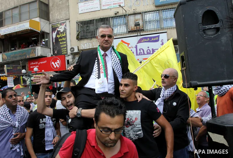 Palestinian Fateh Supporters carry their candidate, Ameen Maqboul, in the West Bank city of Nablus on the first day of campaigning for the local council elections on 06 October , 2012. The elections, scheduled to be held...
