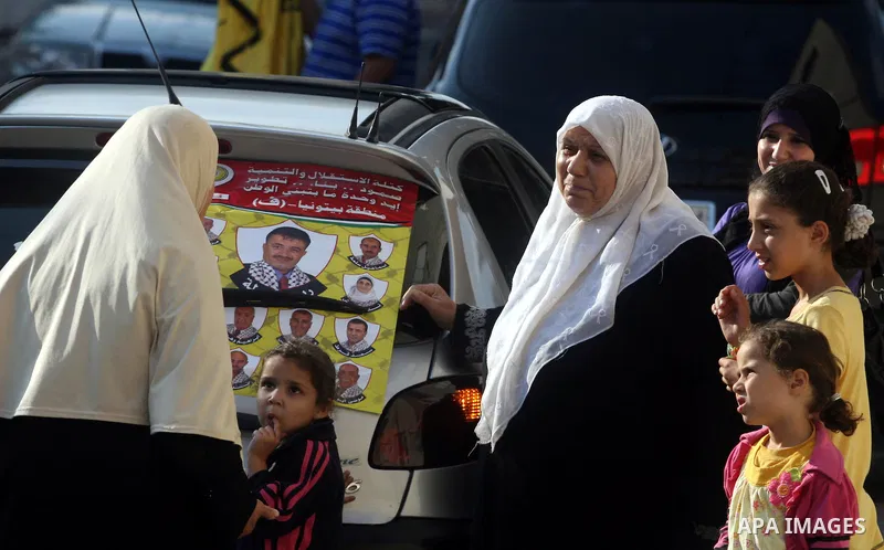 Palestinian women looks at an electoral campaign displaying portraits of candidates running for municipal elections on October 6, 2012 in the West Bank city of Ramallah. Campaigning has started in the West Bank for the O...