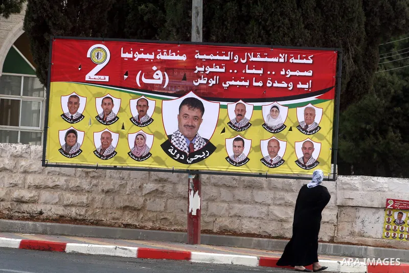 A Palestinian woman looks at an electoral campaign displaying portraits of candidates running for municipal elections on October 6, 2012 in the West Bank city of Ramallah. Campaigning has started in the West Bank for the...