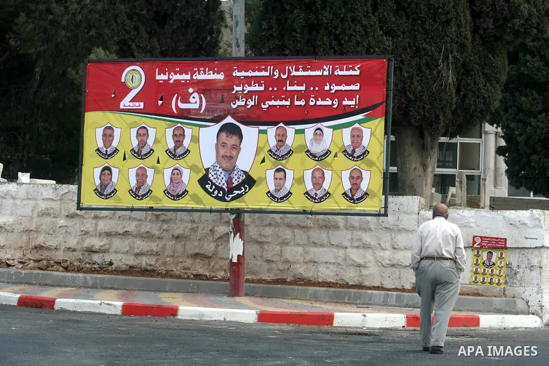 A Palestinian man looks at an electoral campaign displaying portraits of candidates running for municipal elections on October 6, 2012 in the West Bank city of Ramallah. Campaigning has started in the West Bank for the O...