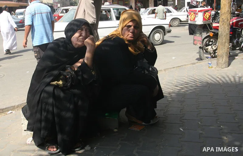 Palestinians wait in front of a center for Social Affairs to receive the financial aid during the program of the Ministry of Social Affairs to help the people with special needs, in Rafah in southern Gaza strip, Oct. 07,...