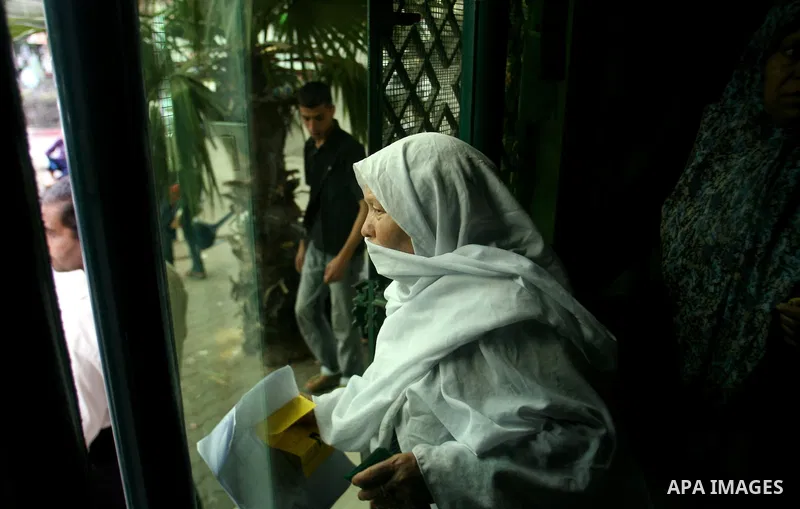 Palestinians wait in front of a center for Social Affairs to receive the financial aid during the program of the Ministry of Social Affairs to help the people with special needs, in Rafah in southern Gaza strip, Oct. 07,...