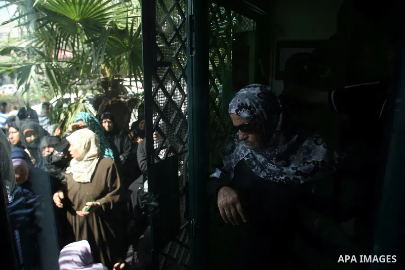 Palestinians wait in front of a center for Social Affairs to receive the financial aid during the program of the Ministry of Social Affairs to help the people with special needs, in Rafah in southern Gaza strip, Oct. 07,...