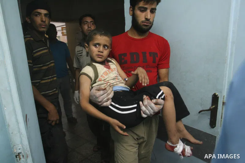 A Palestinian man carries his wounded child in a hospital following an Israeli air strike in Rafah camp in the southern Gaza Strip October 7, 2012. A missile fired by an Israeli aircraft hit and wounded two Palestinian m...