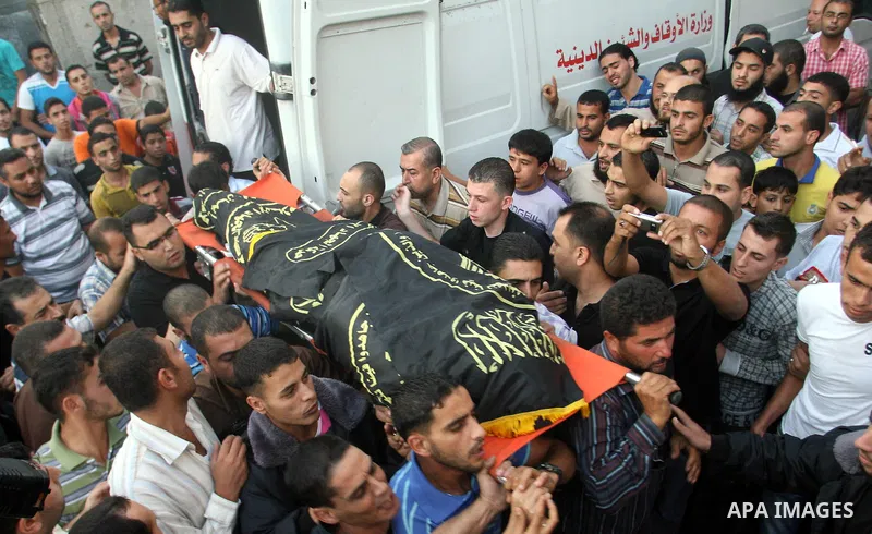 Palestinians carry the body of Abdullah Maqawai during his funeral in Rafah in the southern Gaza Strip on October 8, 2012 after he died of his wounds sustained in an Israeli air strike. Gaza's ruling Hamas movement and t...